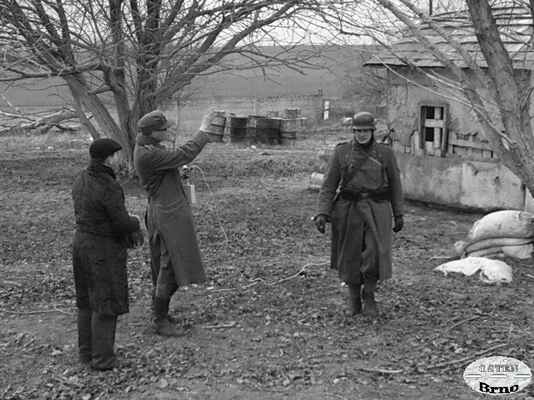 Maďarský civilista hovoří s německým spojařem. Vesnice Tök, Maďarsko 1945