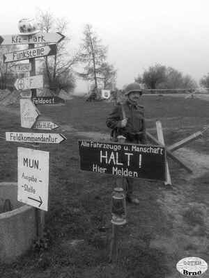 Příslušník Maďarské armády drží stráž u rozcestí. Napravo polní ležení jednotek.
